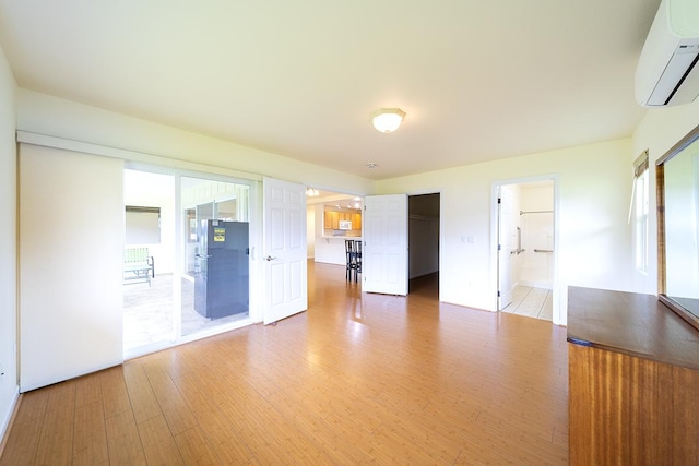 321 Noelani Loop, Hilo, HI 96720 - unfurnished bedroom with a wall mounted AC, light wood-style floors, and connected bathroom