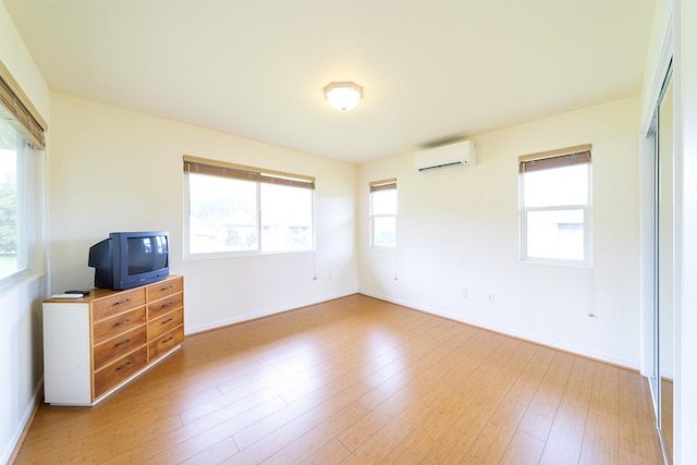 321 Noelani Loop, Hilo, HI 96720 - unfurnished room with an AC wall unit, healthy amount of natural light, and light wood finished floors