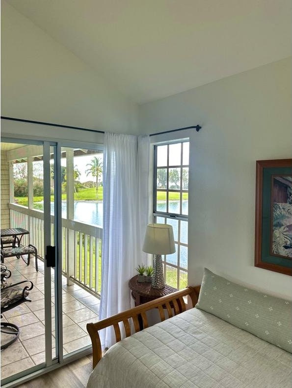 68-3883 Lua Kula St Unit 707, Waikoloa, HI 96738 - bedroom with access to exterior, vaulted ceiling, a water view, and wood finished floors