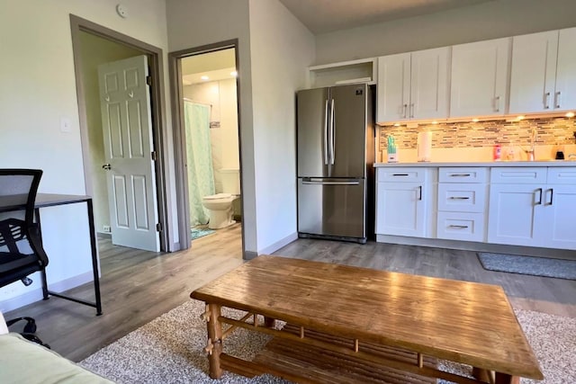 50 Maile St Unit A3, Hilo, HI 96720 - kitchen with freestanding refrigerator, white cabinets, and wood finished floors