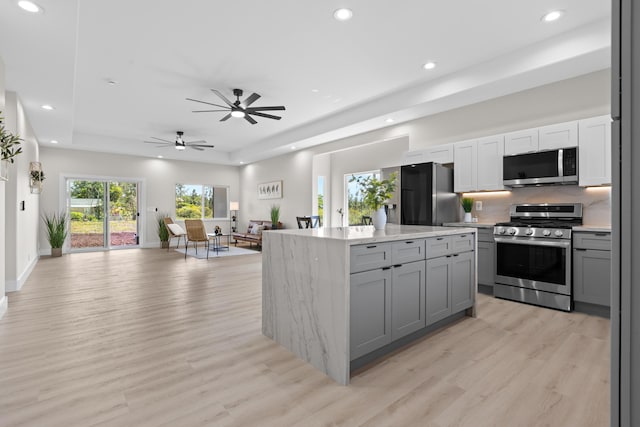 15-1628 Loke Rd, Keaau, HI 96749 - kitchen featuring appliances with stainless steel finishes, gray cabinets, a tray ceiling, open floor plan, and recessed lighting