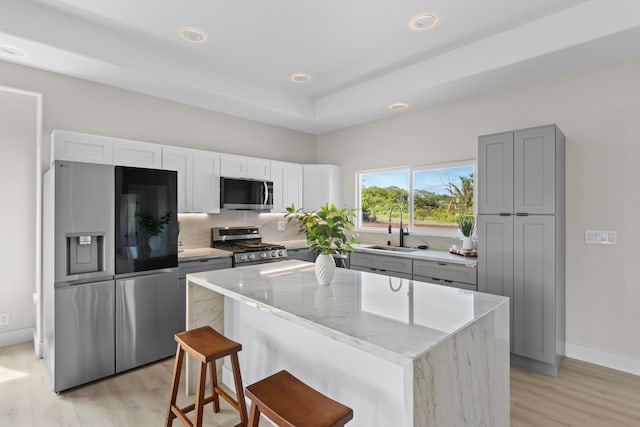 15-1628 Loke Rd, Keaau, HI 96749 - kitchen featuring stainless steel appliances, light stone counters, a kitchen island, light wood finished floors, and tasteful backsplash