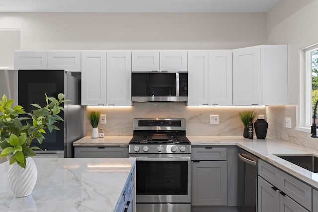 15-1628 Loke Rd, Keaau, HI 96749 - kitchen with appliances with stainless steel finishes, tasteful backsplash, light stone countertops, and gray cabinets