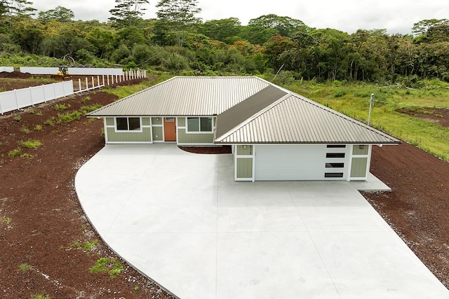 2672 Kuku St, Hilo, HI 96720 - view of front of home featuring a metal roof, a view of trees, concrete driveway, and a garage