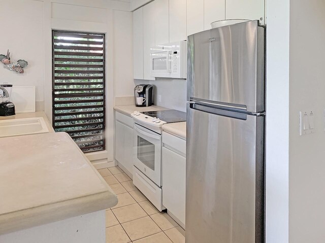 2253 Poipu Rd Unit 28, Koloa, HI 96756 - kitchen with white appliances, light tile patterned floors, and white cabinets