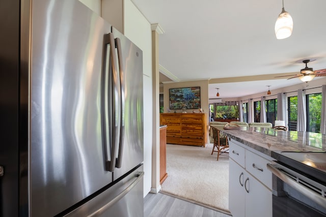 3920 Wyllie Rd Unit 6A, Princeville, HI 96722 - kitchen featuring appliances with stainless steel finishes, a ceiling fan, white cabinets, decorative light fixtures, and light wood-style flooring