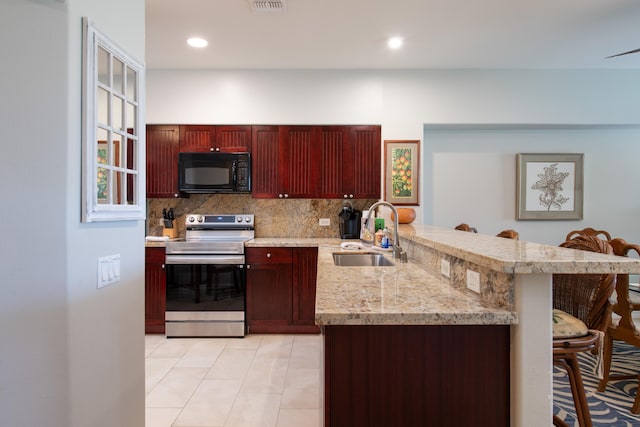 69-200 Pohakulana Pl Unit H22, Waikoloa, HI 96738 - kitchen with black microwave, stainless steel electric range oven, reddish brown cabinets, a peninsula, and a kitchen breakfast bar