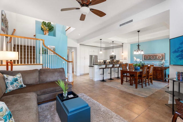 68-1118 N Kaniku Dr Unit 2404, Kamuela, HI 96743 - living area featuring stairs, a raised ceiling, ceiling fan, light tile patterned floors, and a chandelier