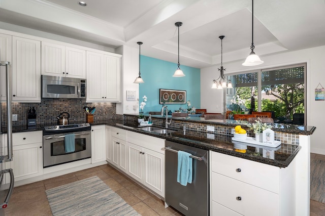 68-1118 N Kaniku Dr Unit 2404, Kamuela, HI 96743 - kitchen with appliances with stainless steel finishes, a raised ceiling, backsplash, a peninsula, and dark stone counters