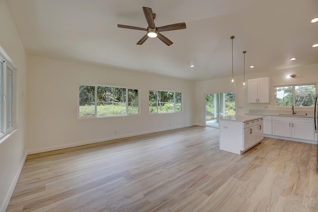 16-1653 34th Ave, Keaau, HI 96760 - kitchen featuring light wood finished floors, open floor plan, white cabinetry, light countertops, and a center island