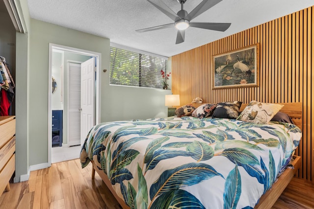 77-301 Noelani Way Unit 12, Kailua-Kona, HI 96740 - bedroom featuring wood finished floors, an accent wall, and ceiling fan