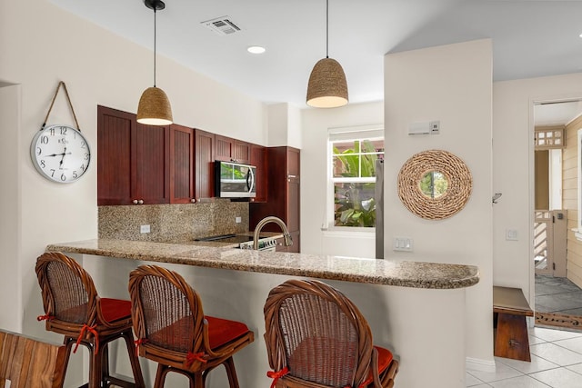 69-200 Pohakulana Pl Unit E2, Waikoloa, HI 96738 - kitchen featuring stainless steel microwave, decorative backsplash, light tile patterned floors, decorative light fixtures, and recessed lighting