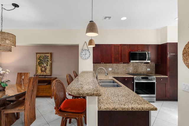 69-200 Pohakulana Pl Unit E2, Waikoloa, HI 96738 - kitchen featuring appliances with stainless steel finishes, a peninsula, dark brown cabinets, and light tile patterned floors