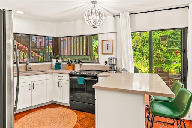3920 Wyllie Rd Unit 10A, Princeville, HI 96722 - kitchen featuring electric stove, a peninsula, tile patterned floors, white cabinets, and light countertops