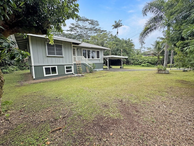 17-312 Volcano Rd, Kurtistown, HI 96760 - view of front facade featuring board and batten siding, a front yard, and a detached carport