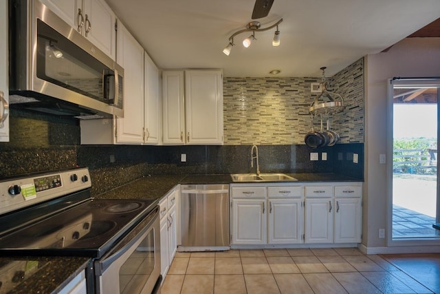 68-1768 Niu Haohao Pl, Waikoloa, HI 96738 - kitchen featuring appliances with stainless steel finishes, white cabinets, dark countertops, decorative backsplash, and light tile patterned floors