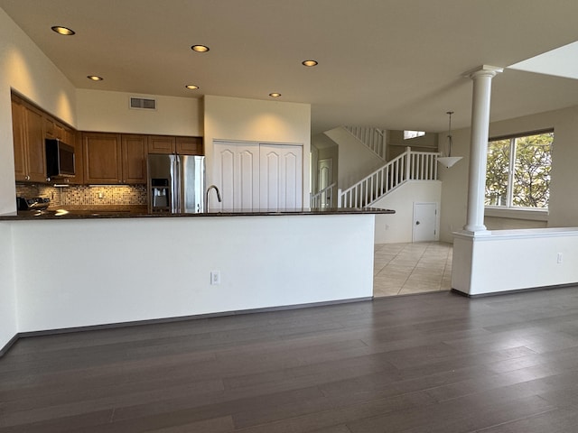 75-6060 Kuakini Hwy Unit E4, Kailua-Kona, HI 96740 - kitchen with stainless steel refrigerator with ice dispenser, dark countertops, ornate columns, recessed lighting, and a peninsula