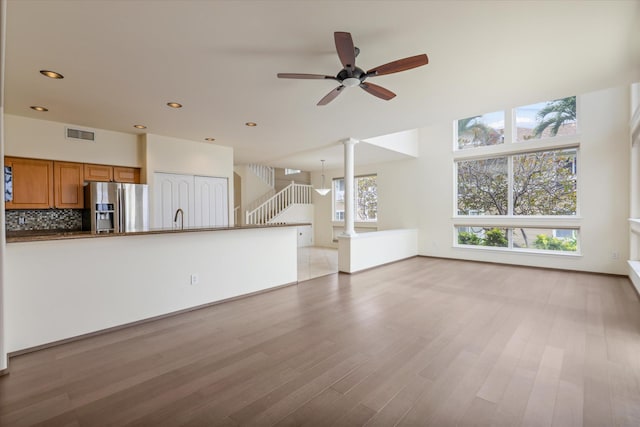 75-6060 Kuakini Hwy Unit E4, Kailua-Kona, HI 96740 - unfurnished living room featuring a ceiling fan, stairway, light wood-type flooring, recessed lighting, and decorative columns