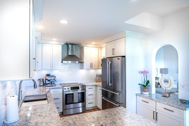 1565 Pee Rd Unit 122, Koloa, HI 96756 - kitchen featuring appliances with stainless steel finishes, wall chimney exhaust hood, backsplash, light stone countertops, and recessed lighting
