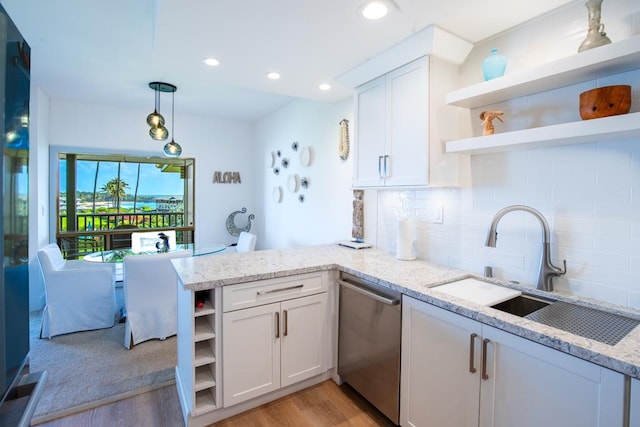 1565 Pee Rd Unit 122, Koloa, HI 96756 - kitchen with open shelves, stainless steel dishwasher, a peninsula, light wood-style flooring, and white cabinets