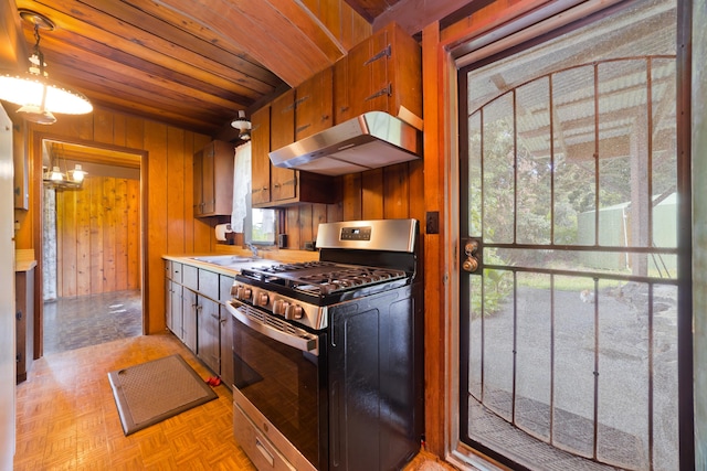 16-1331 Opeapea Rd, Mountain View, HI 96760 - kitchen with gas range, under cabinet range hood, wooden ceiling, wooden walls, and light countertops