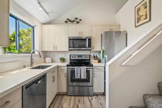 3700 Kamehameha Rd Unit H5, Princeville, HI 96722 - kitchen with stainless steel appliances, vaulted ceiling, track lighting, light brown cabinets, and light countertops
