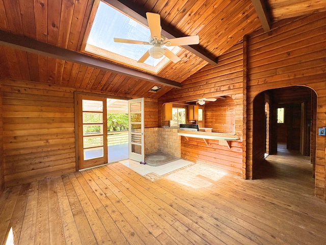 11-3927 8th St, Volcano, HI 96785 - unfurnished living room with arched walkways, ceiling fan, wooden walls, light wood finished floors, and plenty of natural light