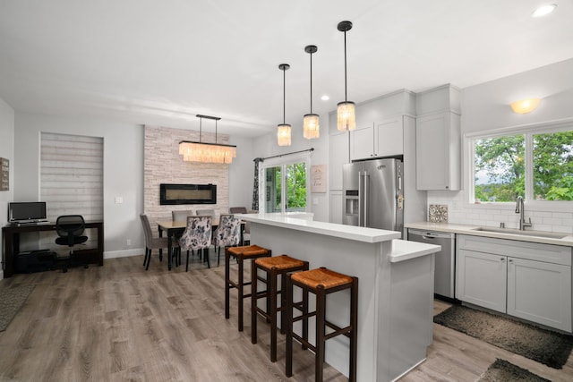 5970-A Heamoi Pl, Kapaa, HI 96746 - kitchen featuring stainless steel appliances, light countertops, a kitchen island, light wood-style flooring, and backsplash