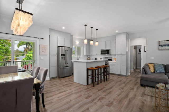 5970-A Heamoi Pl, Kapaa, HI 96746 - kitchen featuring appliances with stainless steel finishes, a breakfast bar, light countertops, open floor plan, and light wood-style floors