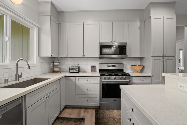 5970-A Heamoi Pl, Kapaa, HI 96746 - kitchen featuring appliances with stainless steel finishes, light countertops, backsplash, wood finished floors, and white cabinets