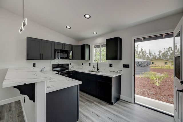 16-2069 Azure Dr, Pahoa, HI 96778 - kitchen featuring black appliances, light wood-style floors, light stone countertops, dark cabinetry, and a peninsula