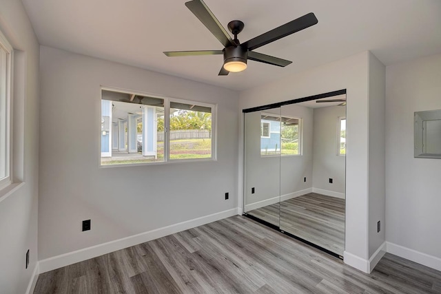 16-2069 Azure Dr, Pahoa, HI 96778 - unfurnished bedroom featuring electric panel, wood finished floors, a closet, and a ceiling fan