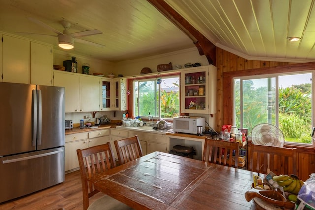 398 Ohai St, Hilo, HI 96720 - kitchen with freestanding refrigerator, white microwave, plenty of natural light, wooden ceiling, and light wood-style flooring
