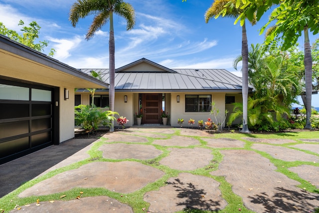 59-217 Lele Naia Dr, Kamuela, HI 96743 - view of front facade featuring a standing seam roof, stucco siding, a metal roof, and covered porch