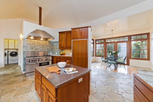 73-4310 Huehue St, Kailua-Kona, HI 96740 - kitchen featuring stainless steel counters, premium appliances, wall chimney range hood, independent washer and dryer, and stone tile flooring
