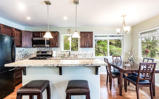 11-3082 Pa Alii St, Volcano, HI 96785 - kitchen featuring appliances with stainless steel finishes, light wood finished floors, a breakfast bar, dark brown cabinetry, and recessed lighting
