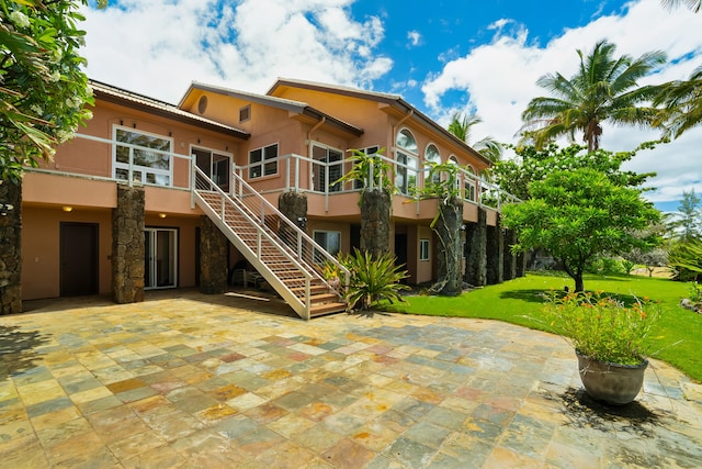 4491 Kikiaola Pl, Kekaha, HI 96752 - back of property featuring stucco siding, stairs, a patio, and a lawn
