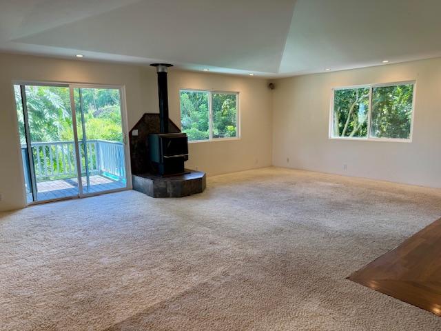 78-6694 Mamalahoa Hwy, Holualoa, HI 96740 - unfurnished living room with carpet, recessed lighting, a wood stove, and a tray ceiling