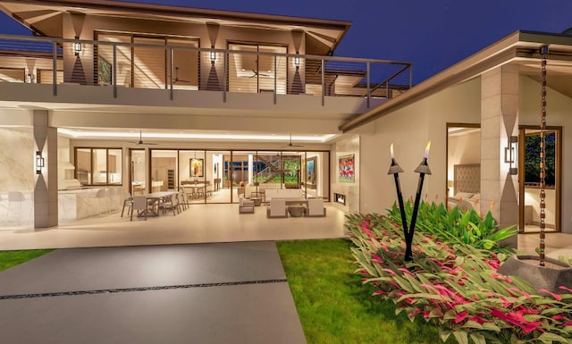 68-1006 Ke Kailani Dr, Kamuela, HI 96743 - back of house at twilight with a balcony, stucco siding, a ceiling fan, and an outdoor hangout area