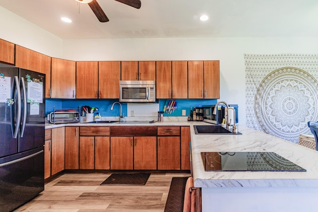 28-238 Akaka Falls Rd, Honomu, HI 96728 - kitchen featuring black fridge, stainless steel microwave, light wood-style floors, light countertops, and a ceiling fan