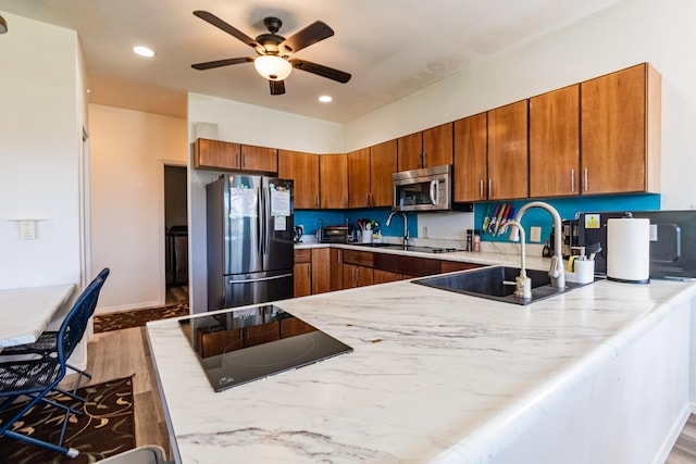 28-238 Akaka Falls Rd, Honomu, HI 96728 - kitchen featuring appliances with stainless steel finishes, a ceiling fan, brown cabinets, a peninsula, and wood finished floors
