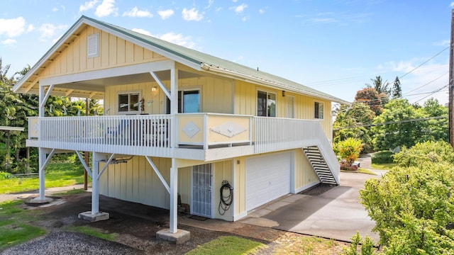55-548 Hawi Rd, Hawi, HI 96719 - view of front facade with an attached garage, stairs, board and batten siding, and driveway