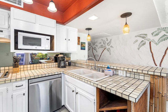 75-6082 Alii Dr Unit A207, Kailua-Kona, HI 96740 - kitchen featuring dishwasher, white microwave, a peninsula, and decorative backsplash