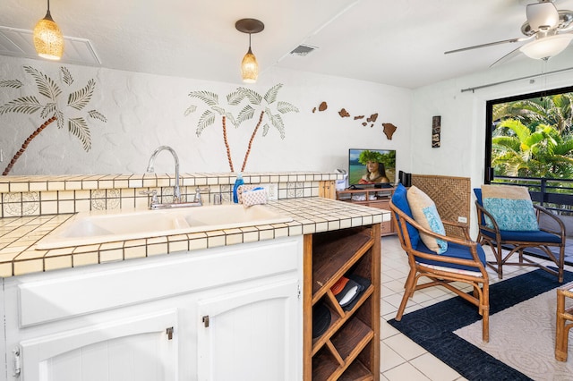 75-6082 Alii Dr Unit A207, Kailua-Kona, HI 96740 - kitchen featuring tile counters, a ceiling fan, light tile patterned floors, white cabinets, and decorative light fixtures