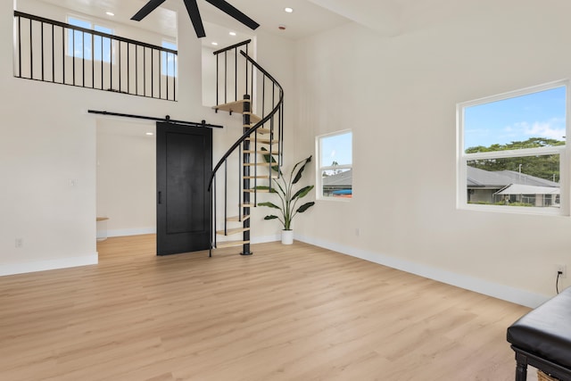 16-2078 Mauna Kea Dr, Pahoa, HI 96778 - unfurnished living room featuring a ceiling fan, healthy amount of natural light, light wood-type flooring, a high ceiling, and a barn door