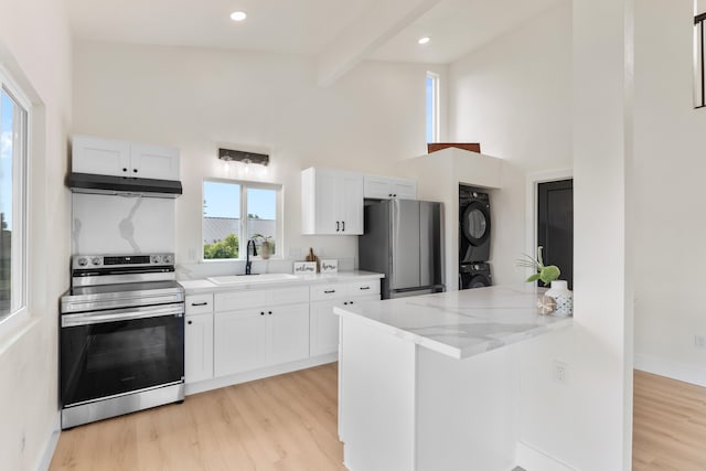 16-2078 Mauna Kea Dr, Pahoa, HI 96778 - kitchen with stainless steel appliances, stacked washer / drying machine, under cabinet range hood, light wood-style floors, and beam ceiling