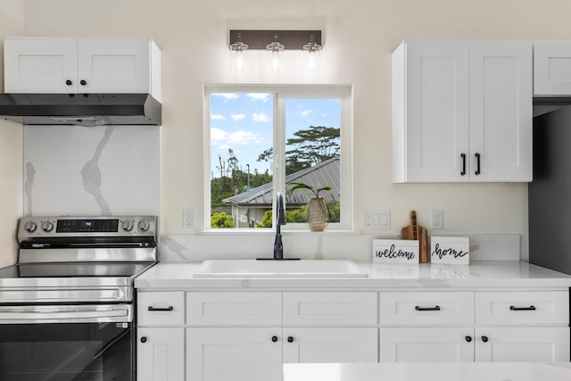 16-2078 Mauna Kea Dr, Pahoa, HI 96778 - kitchen with stainless steel range with electric stovetop, under cabinet range hood, white cabinets, and light countertops