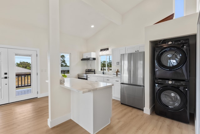 16-2078 Mauna Kea Dr, Pahoa, HI 96778 - kitchen featuring appliances with stainless steel finishes, stacked washer / drying machine, high vaulted ceiling, beamed ceiling, and light wood finished floors