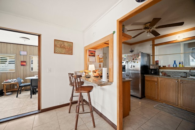 7786 Ulili Rd, Kekaha, HI 96752 - kitchen featuring stainless steel refrigerator with ice dispenser, a ceiling fan, crown molding, brown cabinets, and light tile patterned flooring