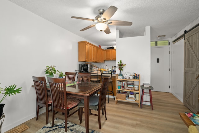 3-3400 Kuhio Hwy Unit B101, Lihue, HI 96766 - dining area featuring a barn door, light wood-style floors, ceiling fan, and a textured ceiling